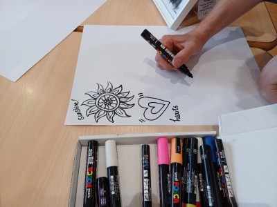 Image is a close up view of someone drawing a botanical design.