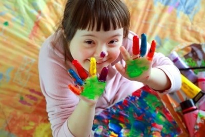 Young girl showing hands covered with paint